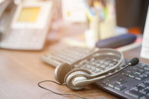 close up focus on call center headset device at computer keyboard office desk for hotline t20 9lpQa8